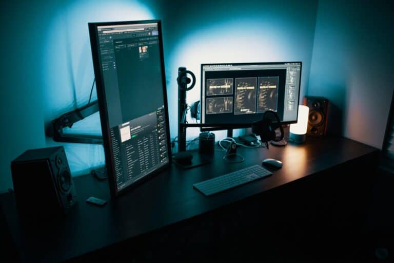A monitor and a desktop on the table with a lamp beside it