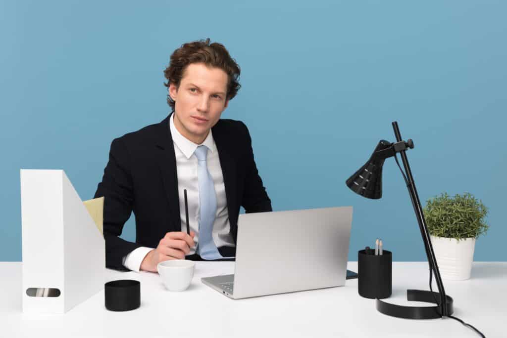 A business owner planning data recovery strategies looks off pensively while sitting at his desk.