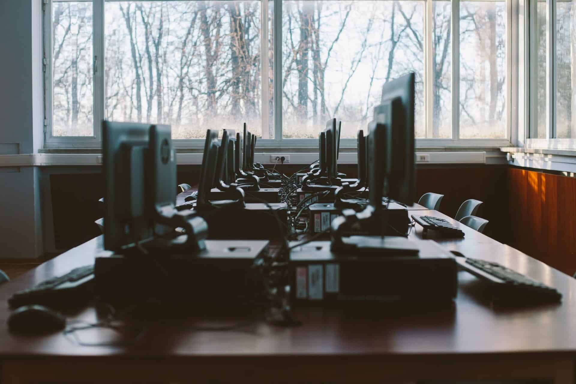 Several computers are interconnected near a window.