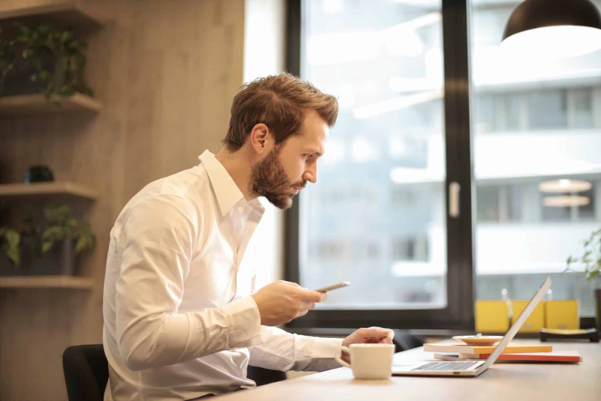 A businessman looks over his computer as he makes certain that his new business is fully compliant.