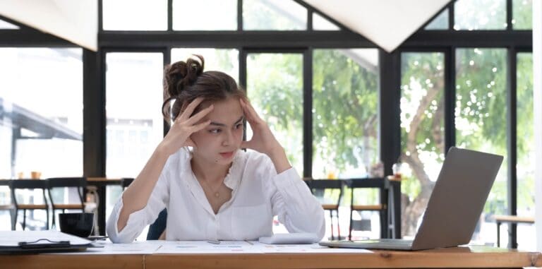 A business owner looks worriedly at her laptop as she realizes she’s a victim of a data breach.