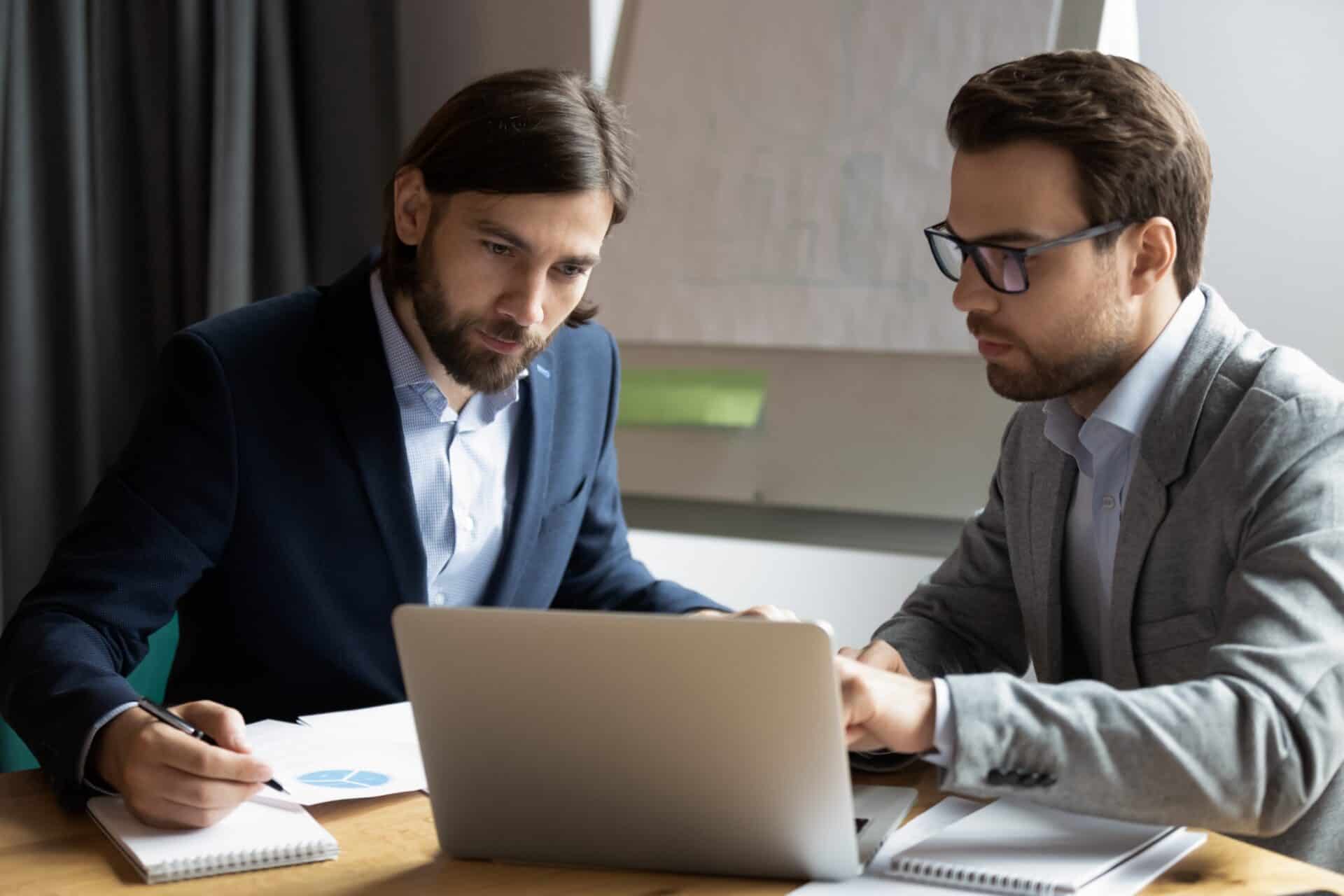 An IT specialist shows a business owner on a laptop how to fortify email security for his business.