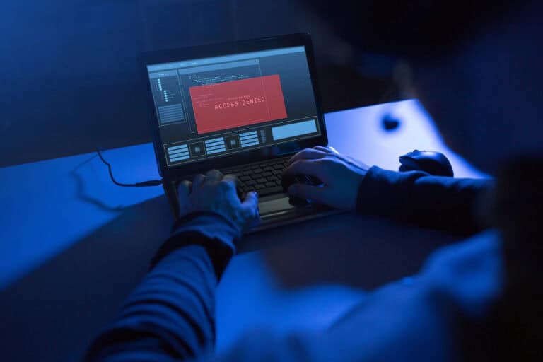 Hacker attempting access with red access denied warning on screen