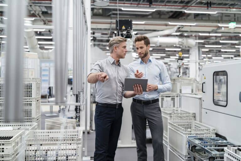 two-businessmen-with-tablet-talking-in-a-modern-factory