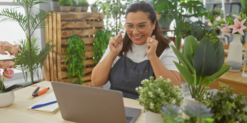 A happy small business owner celebrates growth driven by successful business scalability.