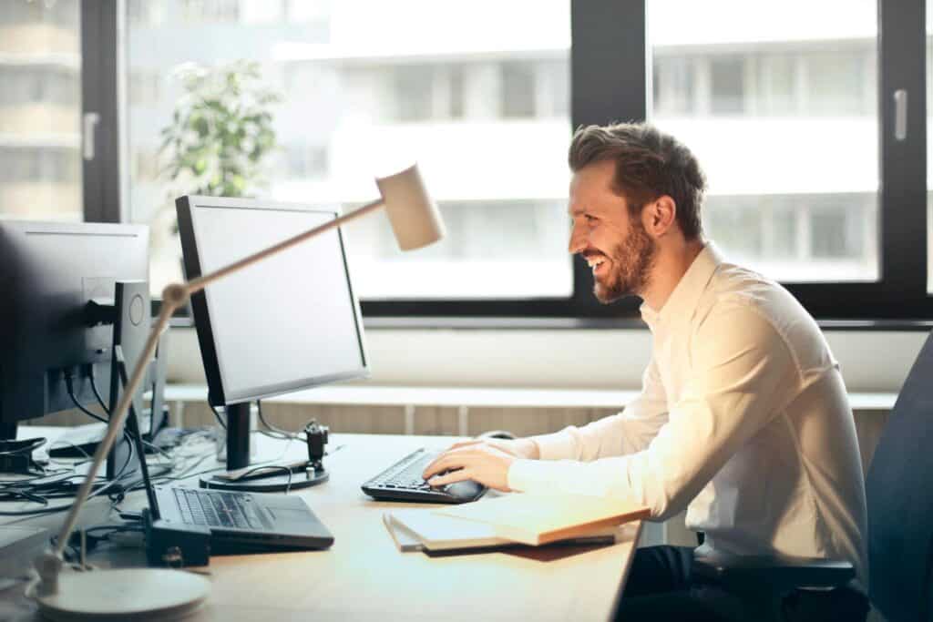 A man sits at a desk with a computer and works on a project.