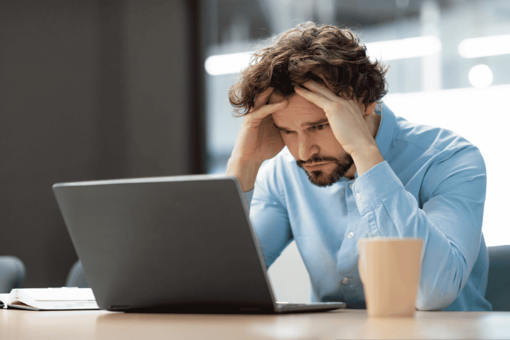 Sad business man grabbing head using laptop stock photo