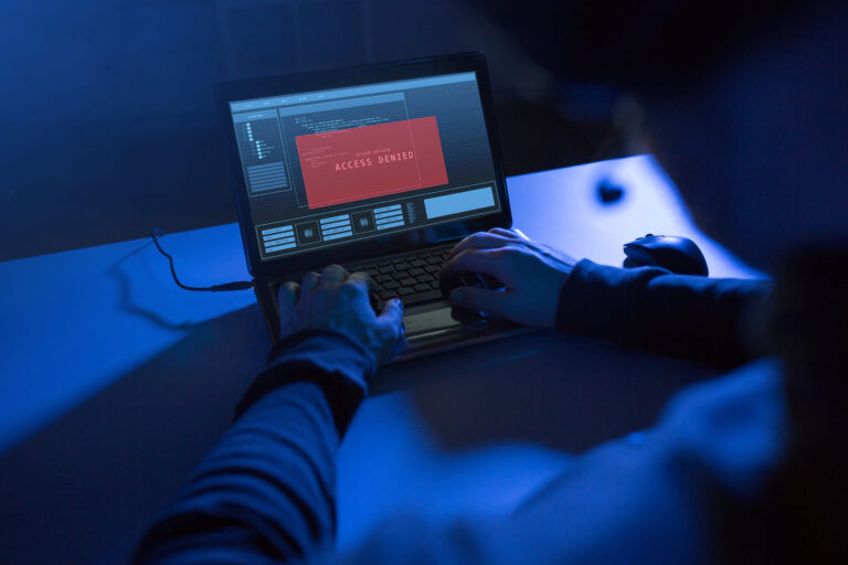 Hacker attempting access with red access denied warning on screen