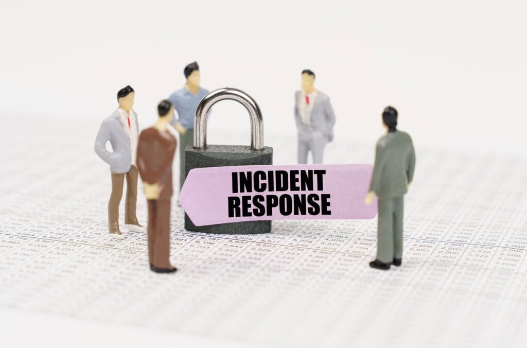 The concept of security in business. There are figures of people on business reports, a padlock with a sticker on which it is written - Incident response