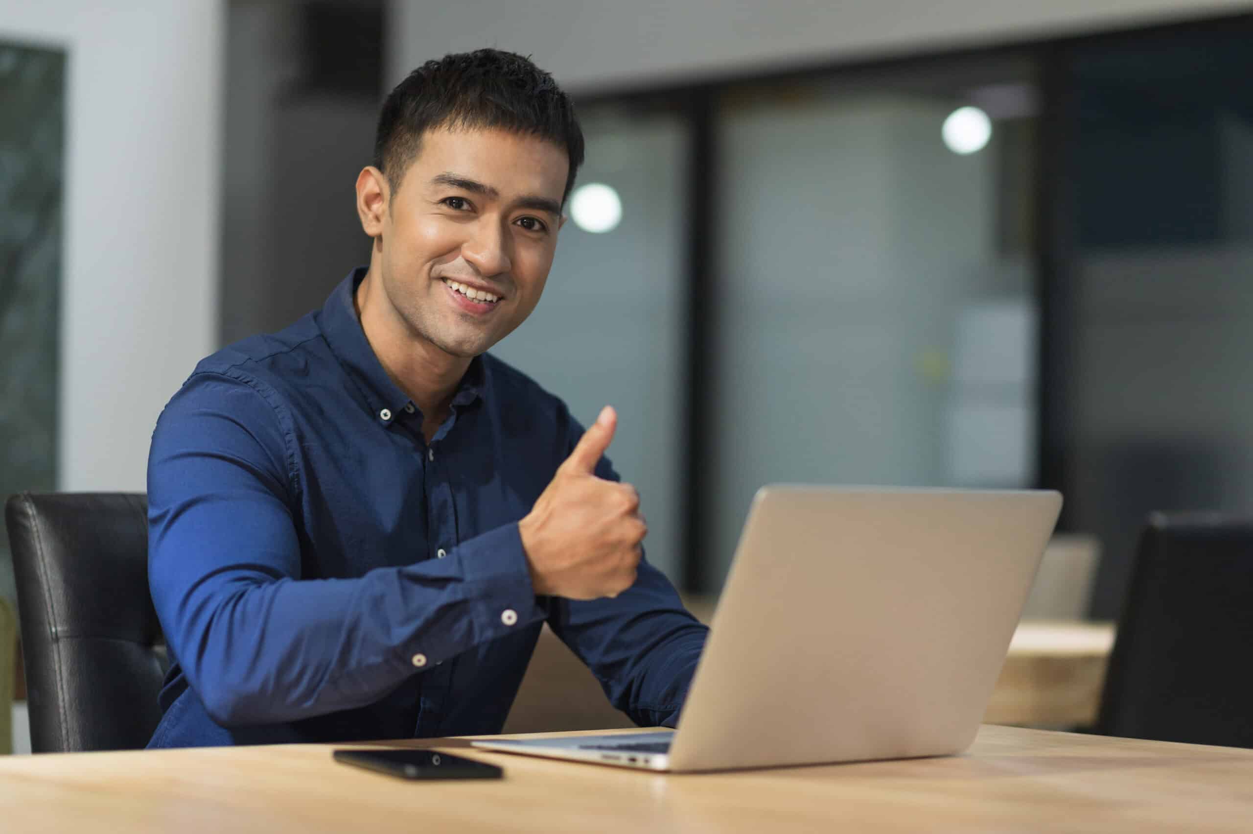 A business owner gives a thumbs up with a smile as he secures an MSP for his business.