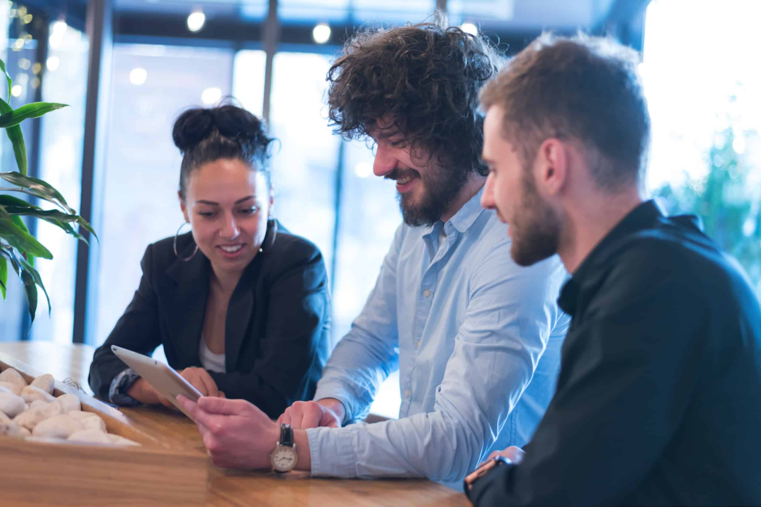 An IT specialist shows two business owners how to use multi-factor authentication on a tablet.