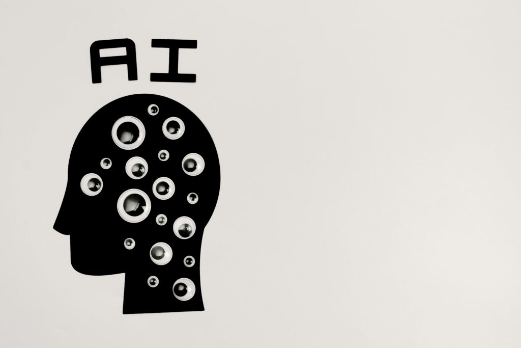 The word “AI” written above a human head illustration with eyes inside it