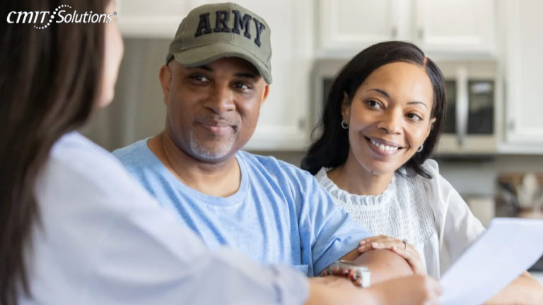 Couple sits with a clinician in a bright kitchen, examining a document together and smiling.