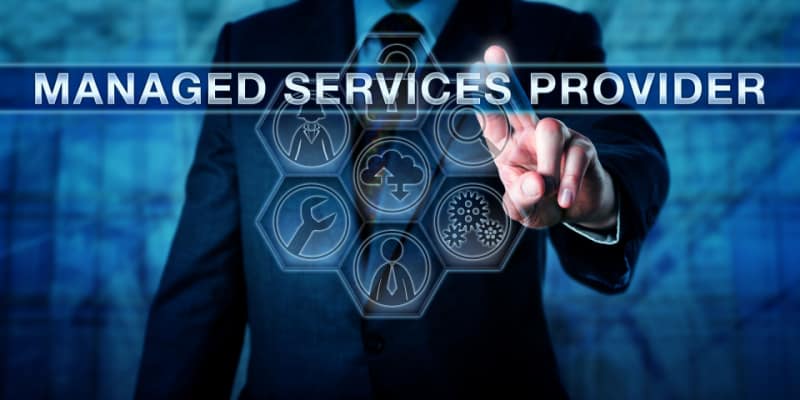 A professional pressing MANAGED SERVICES PROVIDER on an interactive virtual screen illustrates the IT Procurement process by Managed IT Service Providers.