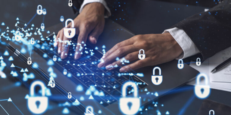 Person typing on a laptop with digital padlock icons and network graphics, representing enterprise-level cybersecurity and data protection.