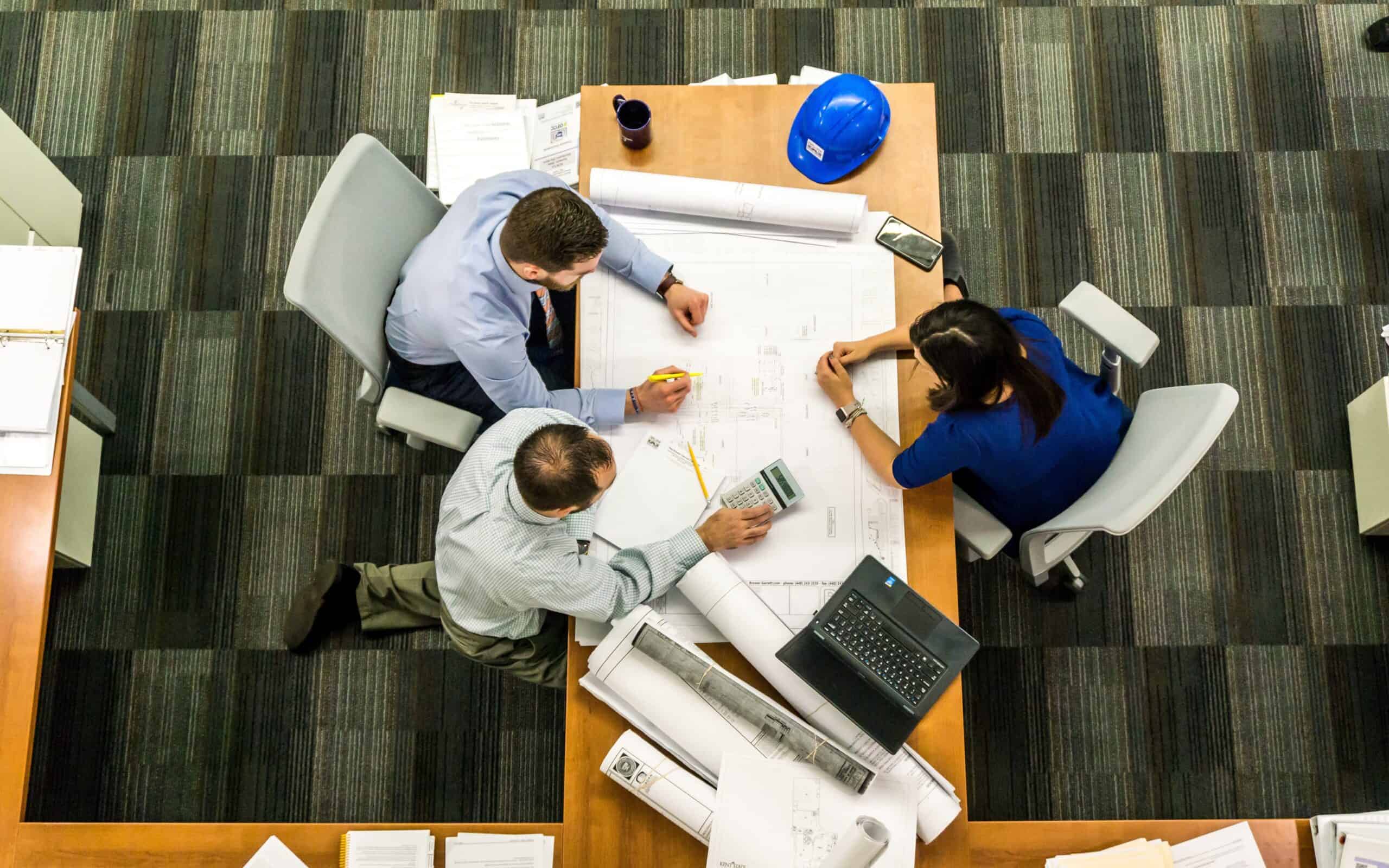 three people sitting beside table discussing it services for nonprofits