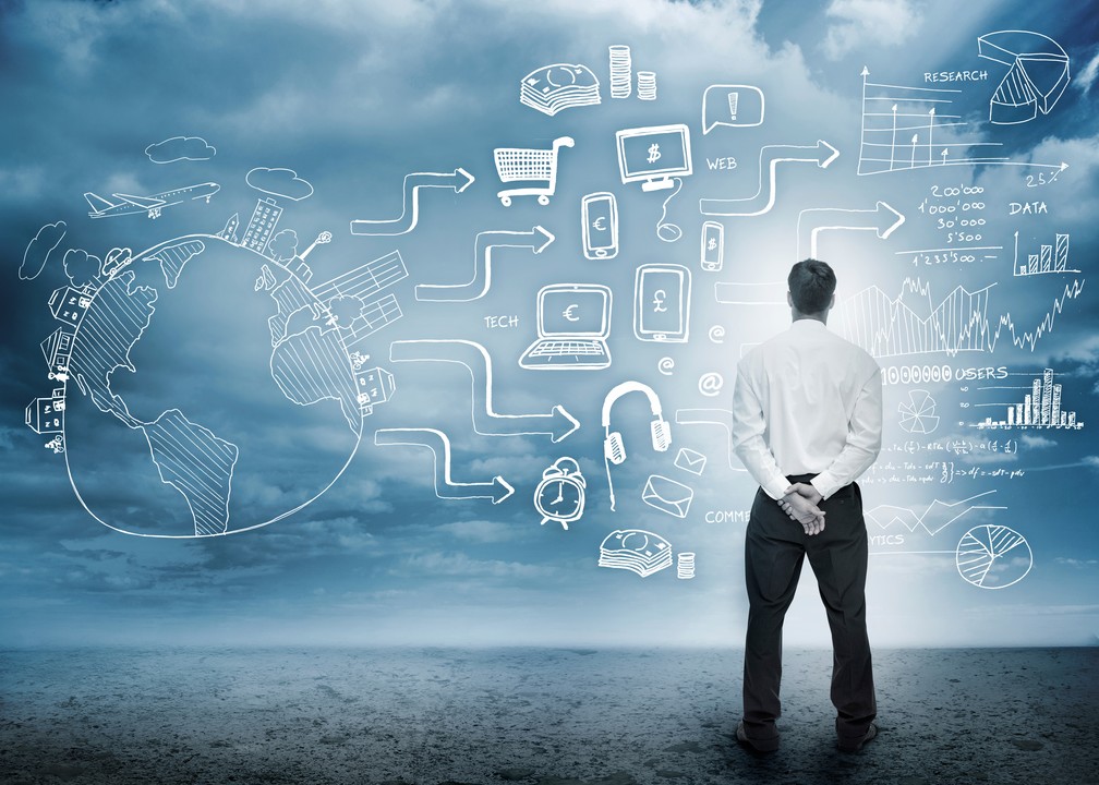 Businessman studying global tech concepts and data visuals drawn in white chalk against a cloudy sky backdrop, symbolizing digital strategy.