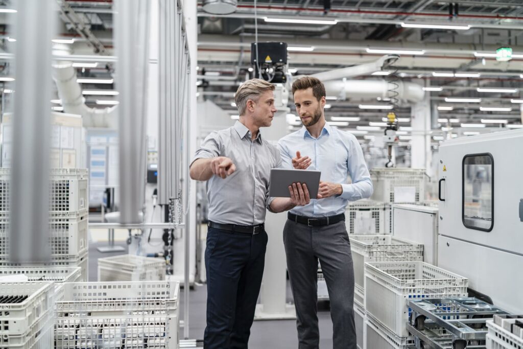 two-businessmen-with-tablet-talking-in-a-modern-factory