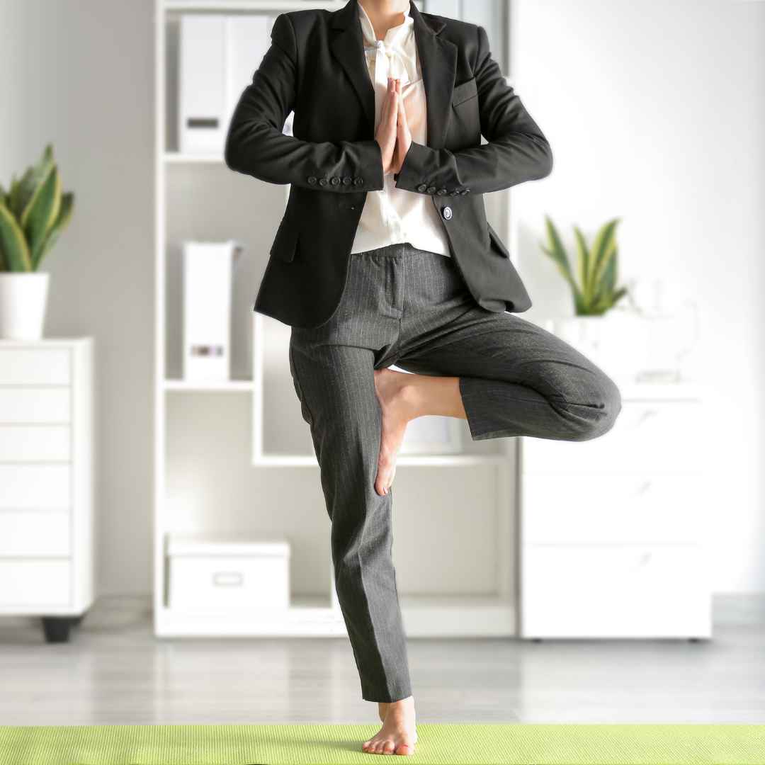 Business professional practicing yoga in an office, representing balance in healthcare cybersecurity.