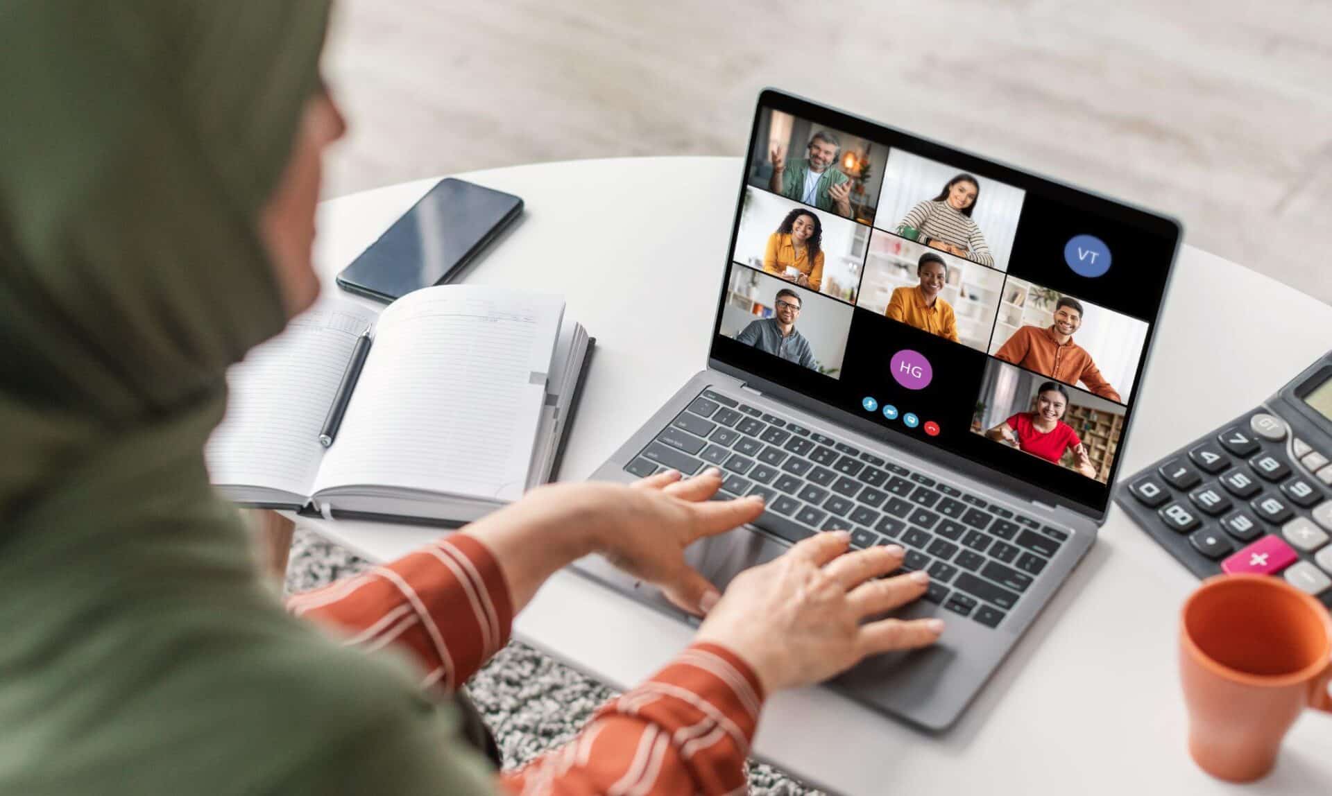 A woman attends a virtual meeting on her laptop.