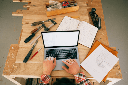 man working on computer surrounded by tools