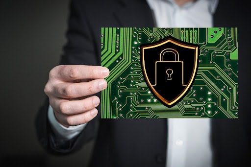 A man in a business suit holding a photo of a data security padlock emblem.