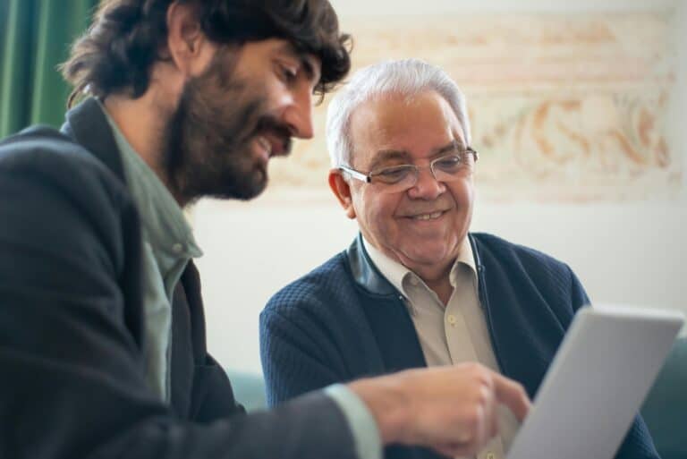 An IT specialist works with a business owner on a laptop to plan ransomware protection strategies.