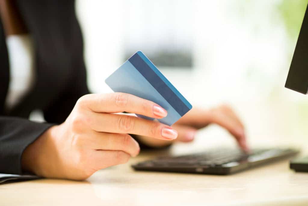 A customer on an e-commerce site gets their credit card ready to make a purchase.