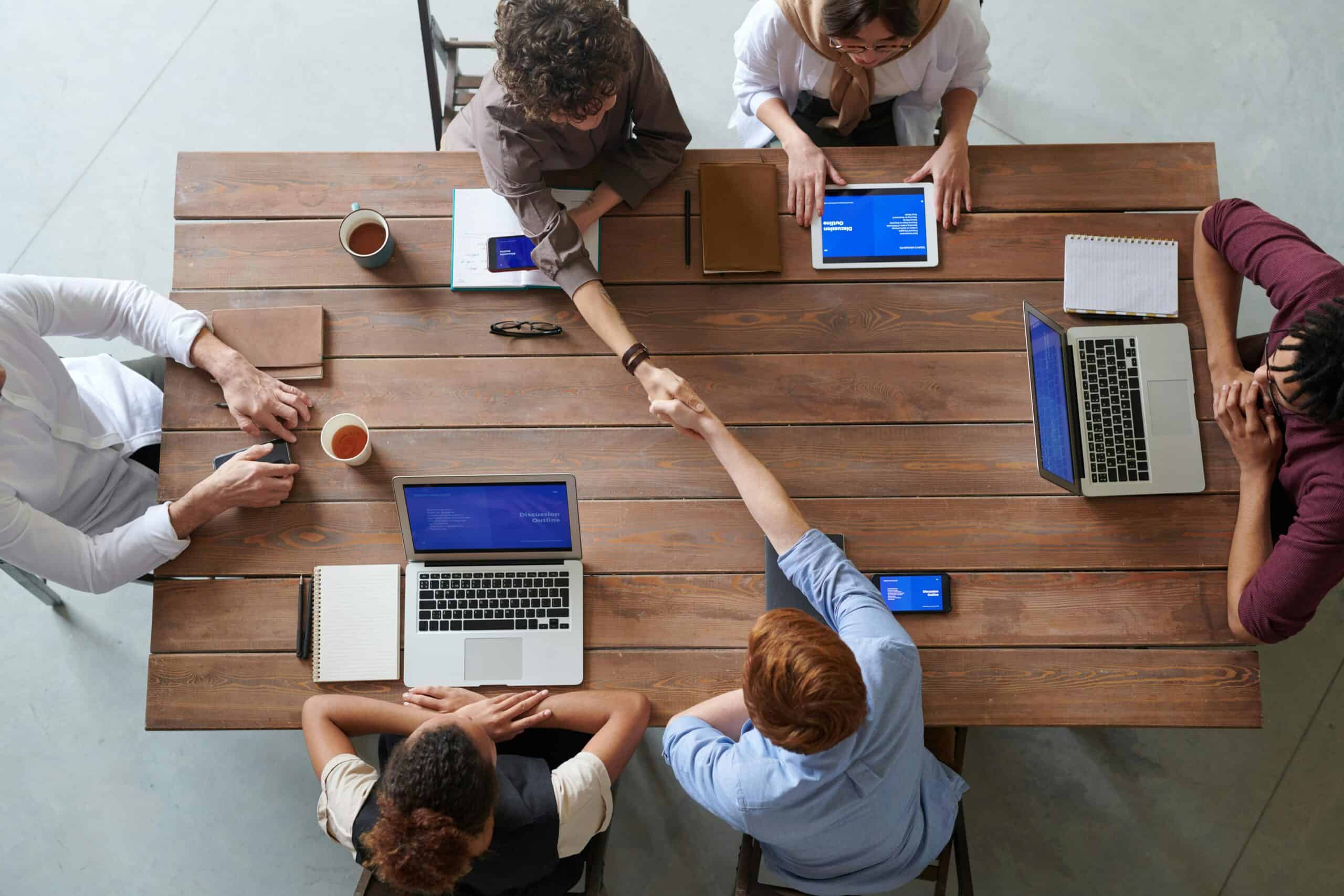 Employees collaborate at a desk in the office with the help of productivity apps.