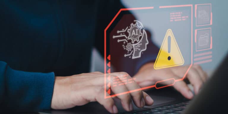 A person using a laptop displaying artificial intelligence graphics, representing AI-driven cyberattacks targeting U.S. businesses during the holiday season.
