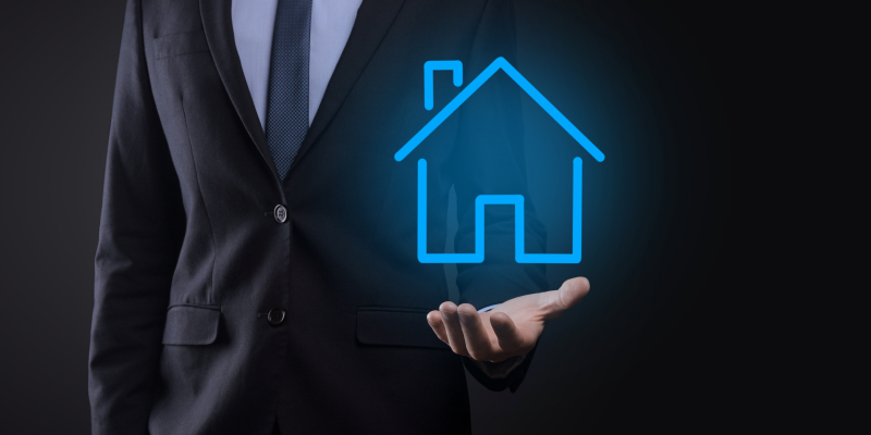 A professional holding a real estate icon, symbolizing the role of a complete tech managed services.