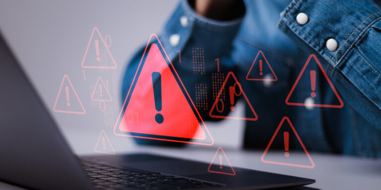 A distressed man sits in front of a laptop displaying a ransomware alert, with a worried expression on his face.