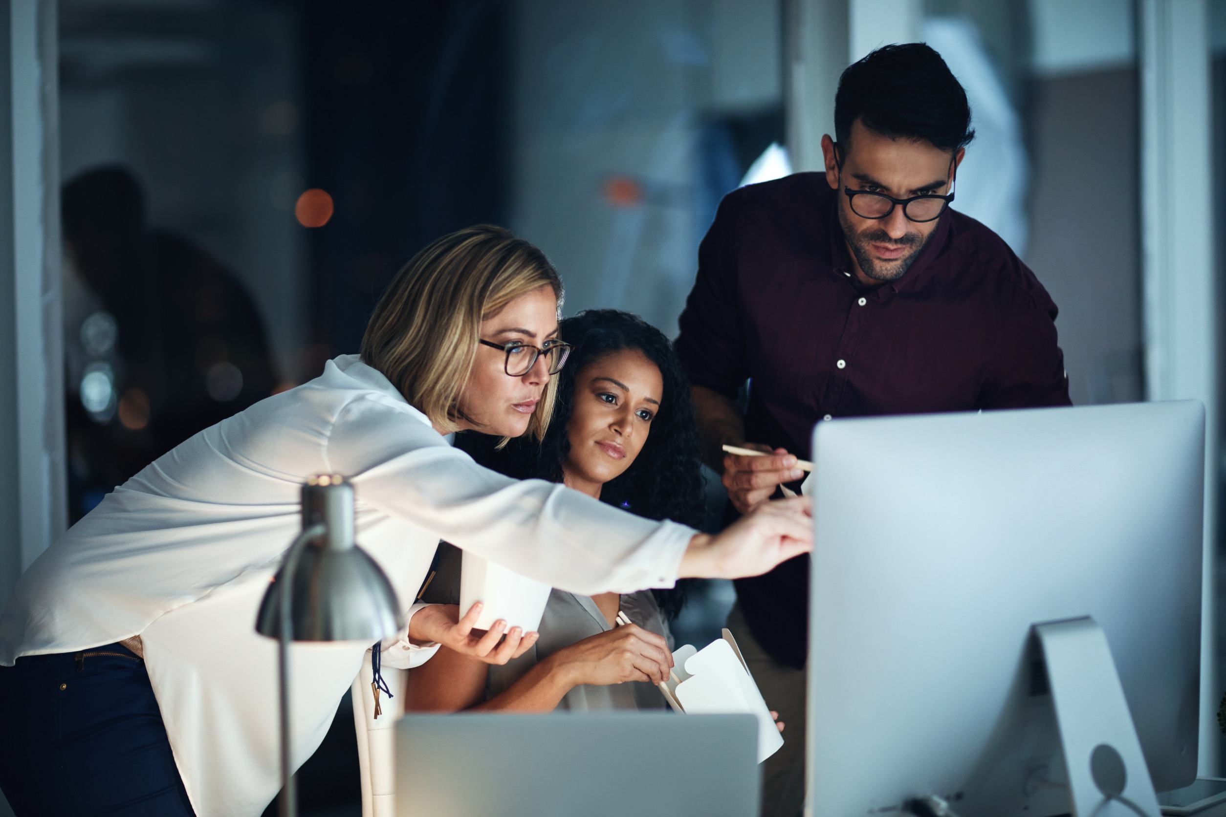 A business owner works with her IT team to create a disaster recovery plan together on a computer