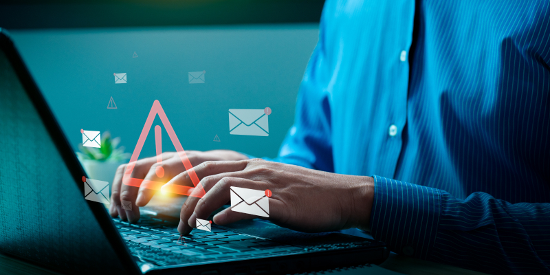 Email security concept showing a phishing attack warning on a businessman's laptop screen.