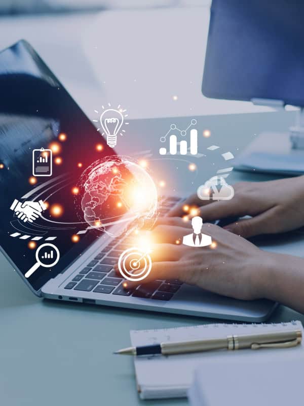 Hands typing on a laptop with glowing holographic icons (globe, light bulb, charts, cloud, handshake) symbolizing innovation and digital collaboration.