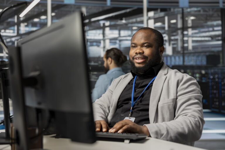 cheerful-data-center-employee-working-on laptop
