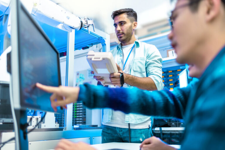 engineers-programming-robotic-arm-in-technology-workplace