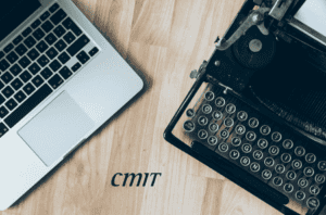 a computer next to a typewriter