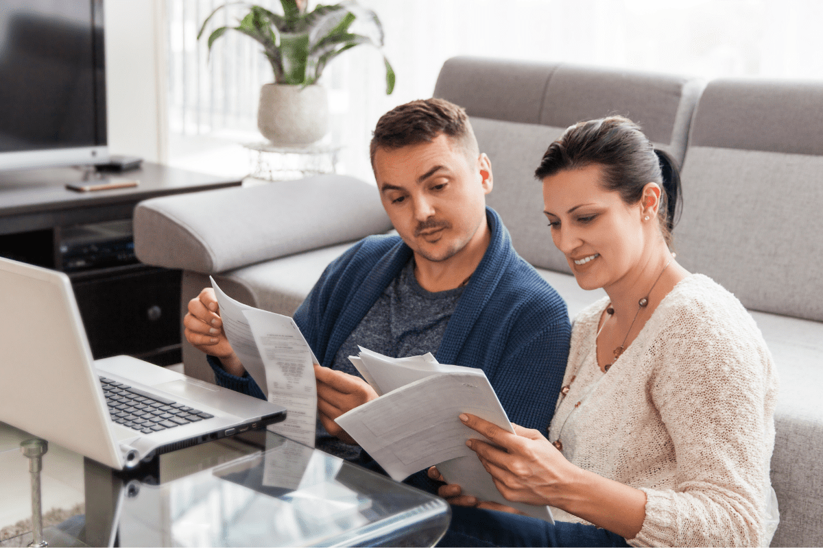 Man and woman looking at paperwork in front of laptop_Feature