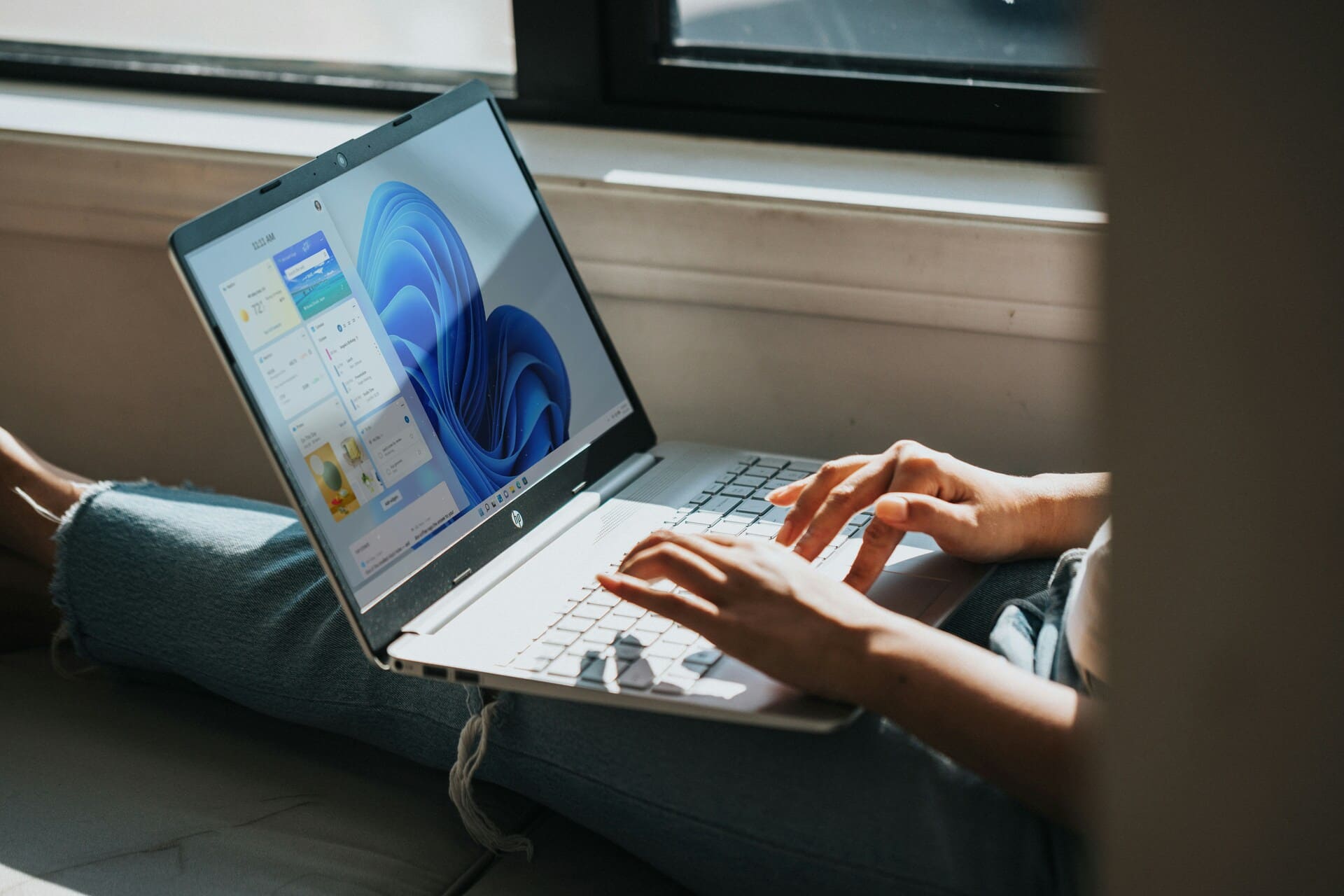 Person sitting casually and working on a Windows 11 laptop