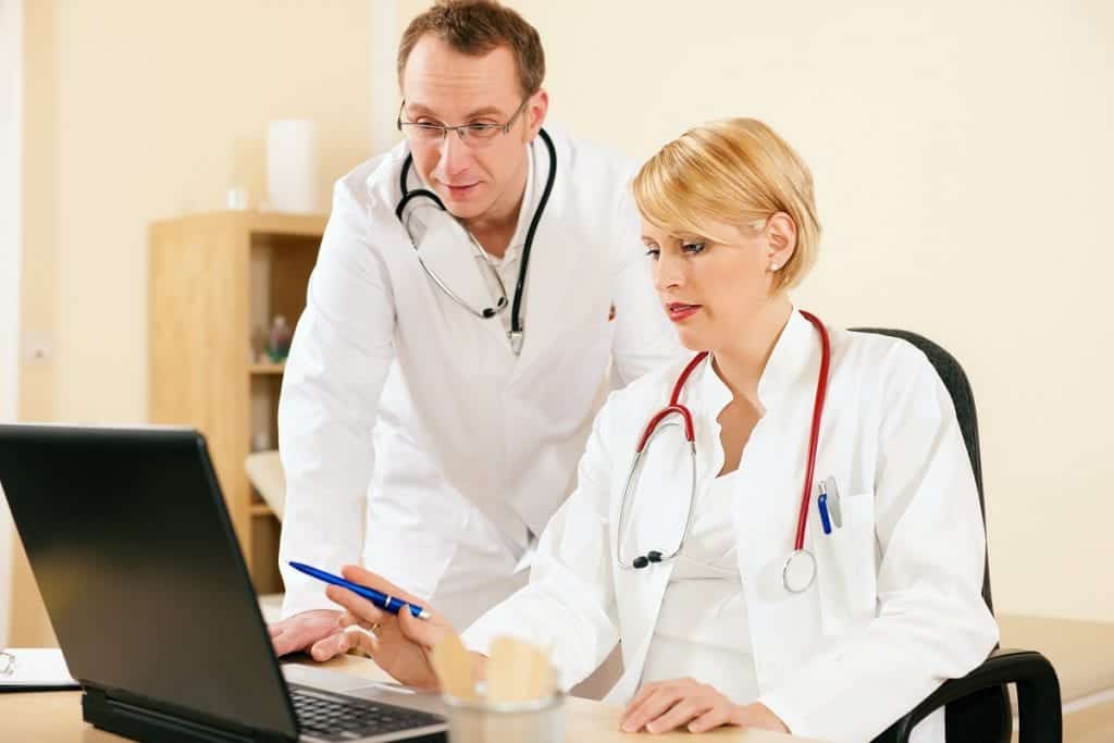 two doctors looking at a laptop
