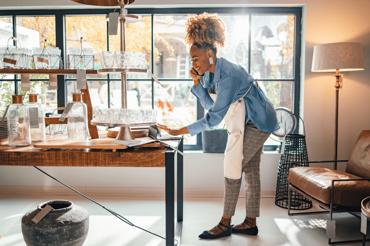 Smiling Business Woman Talking On A Mobile Phone In Her Store stock photo