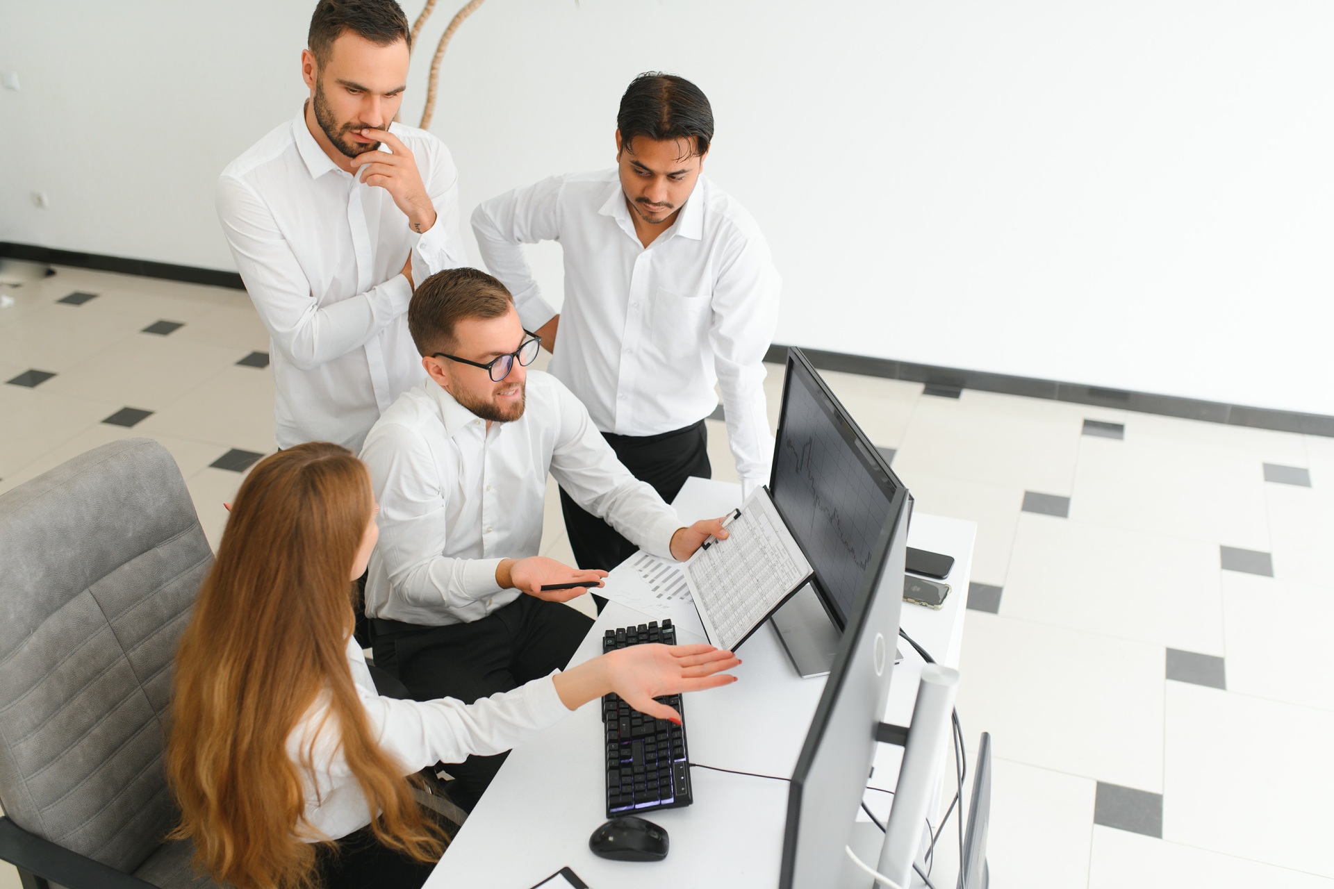 happy business people laughing while collaborating in front of computer