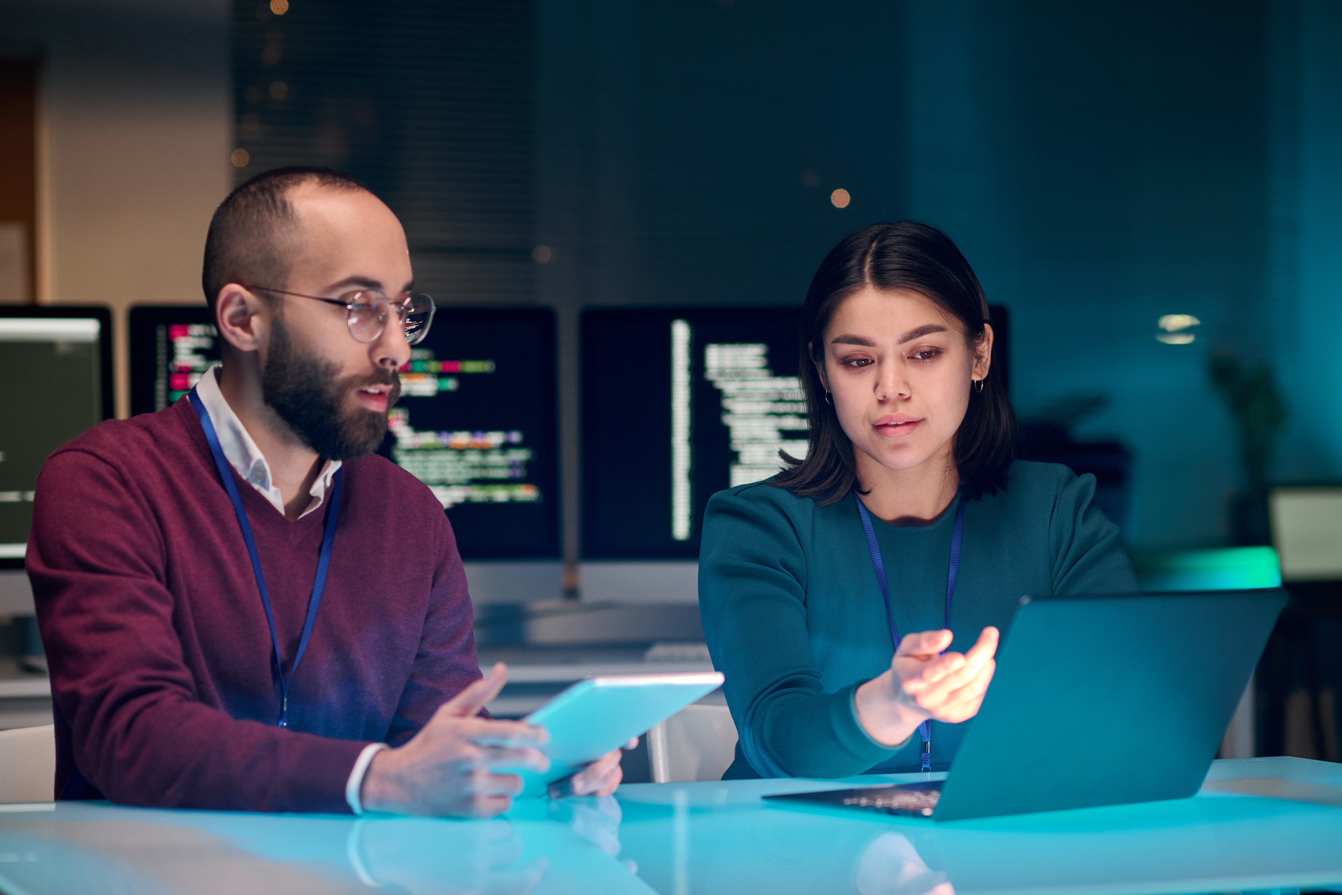 female it expert using laptop with colleague