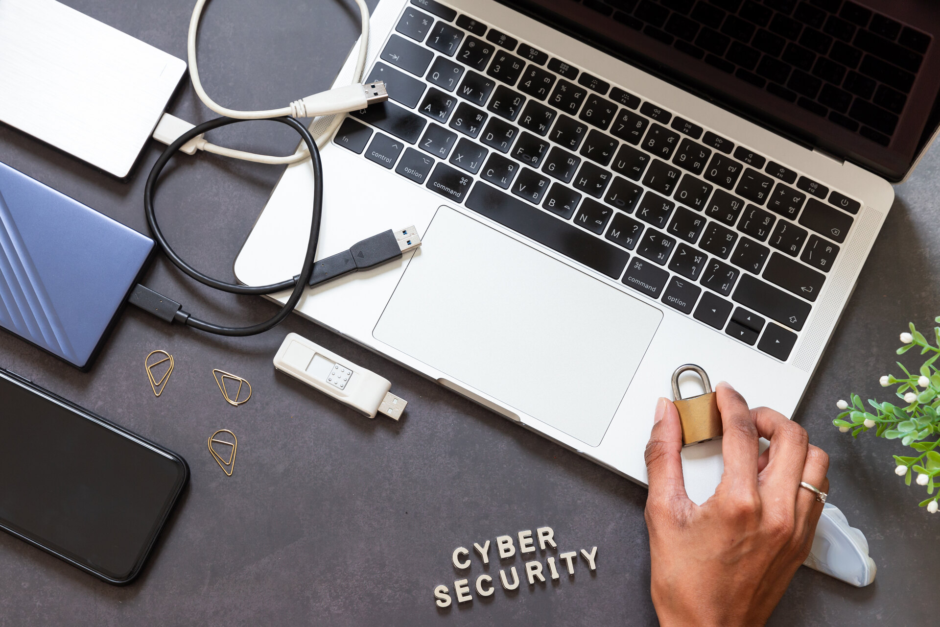 hand holding padlock over laptop | CMIT Solutions hand holding padlock over laptop