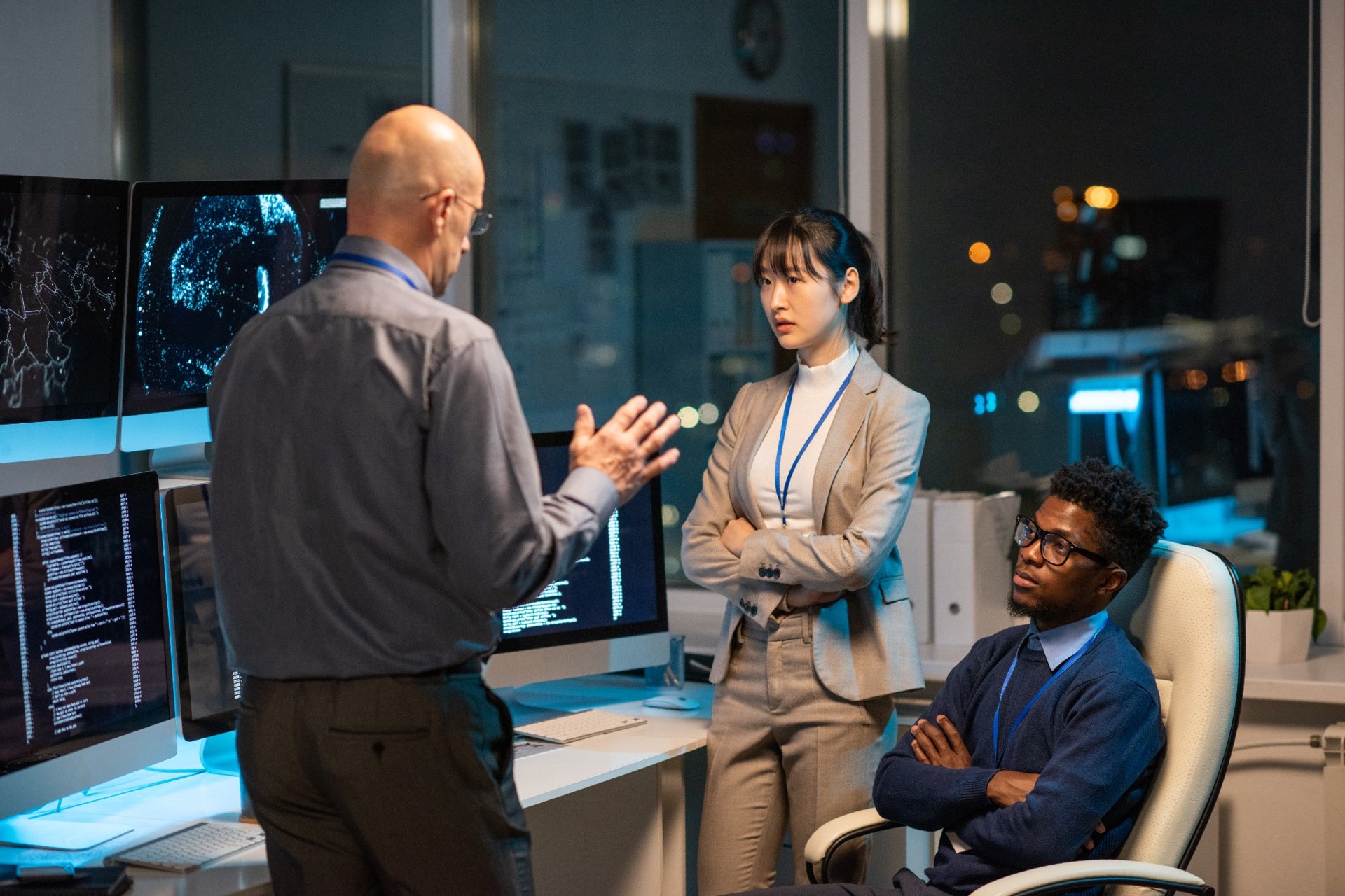 Supervisor talking to analysts in IT command center