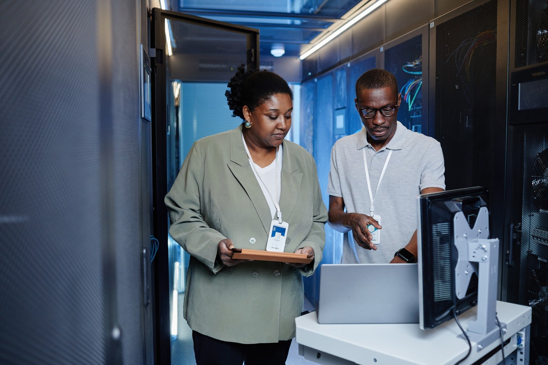 Two IT professionals inspecting server data center setup