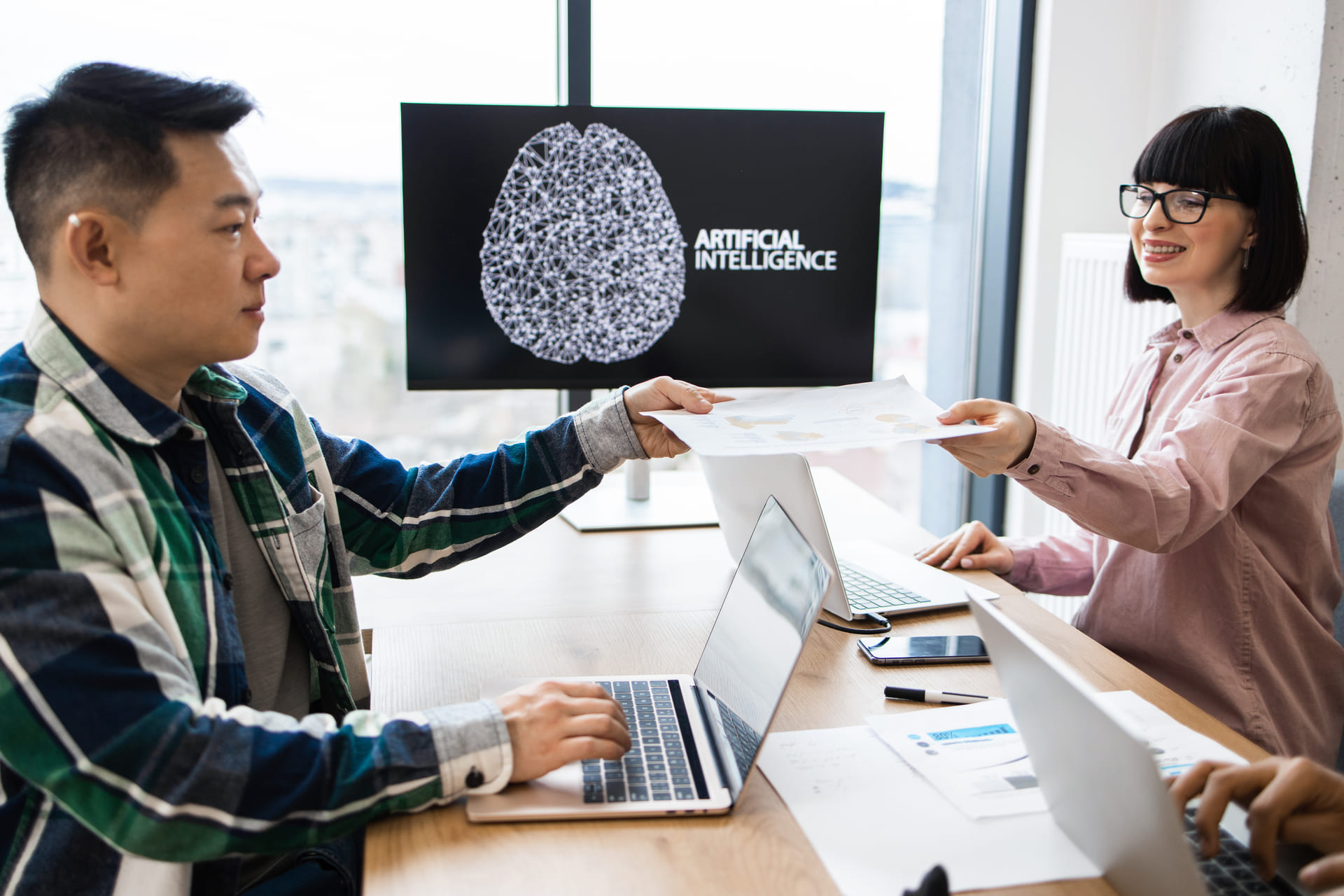Coworkers collaborating on AI project at desk