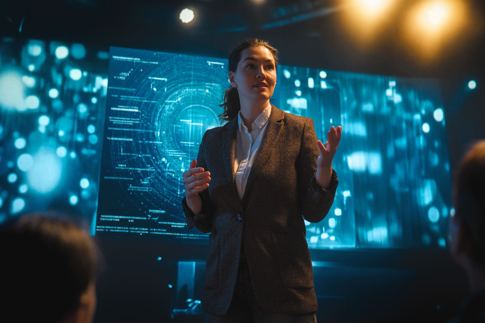 Female professional giving a presentation with a digital screen behind her