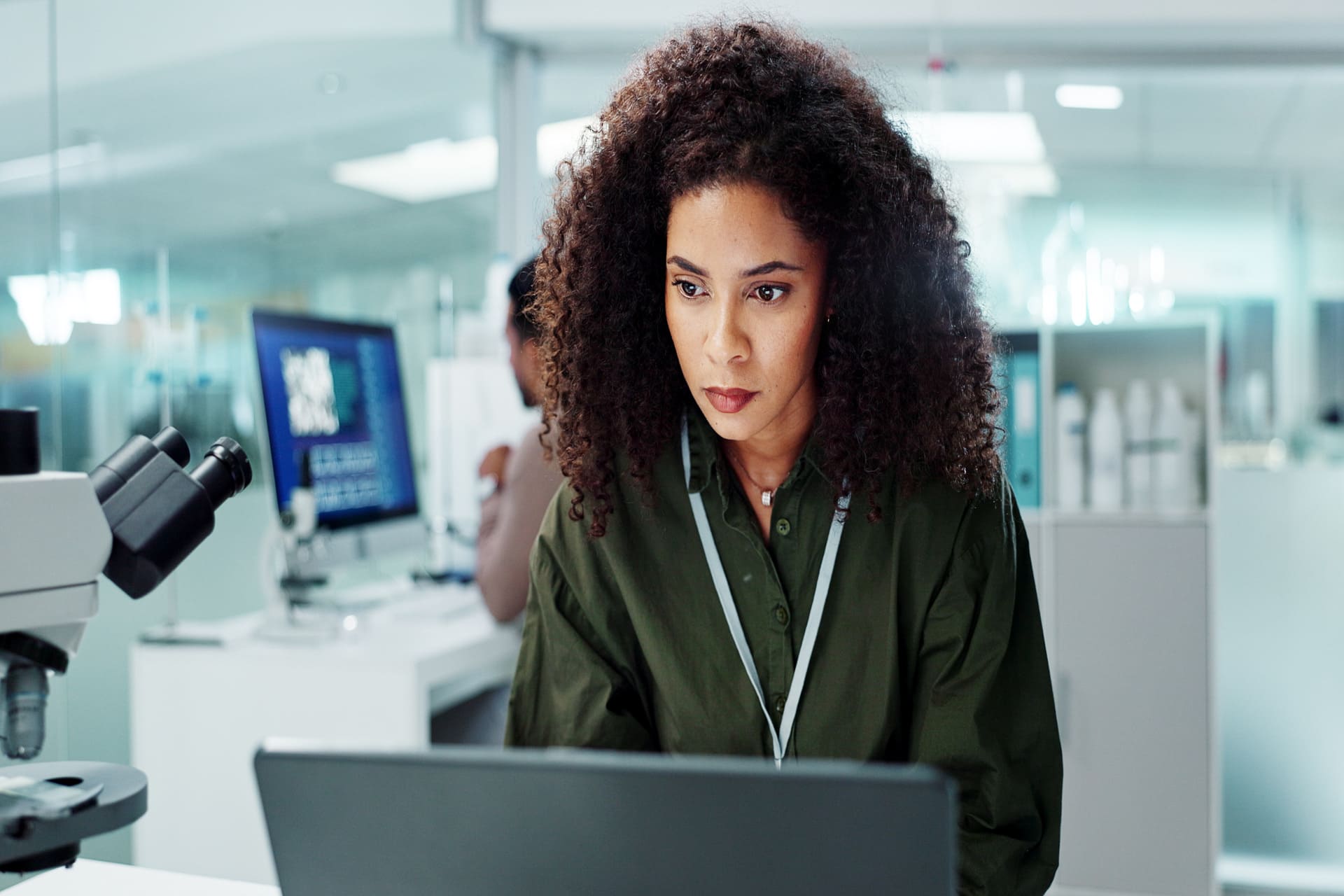 Focused woman working on laptop in a laboratory setting